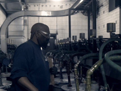 An Ink Technician is walking through the dispenser room in slow motion